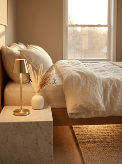 Luma Rechargeable Touch Lamp on marble bedside table in minimal bedroom setting